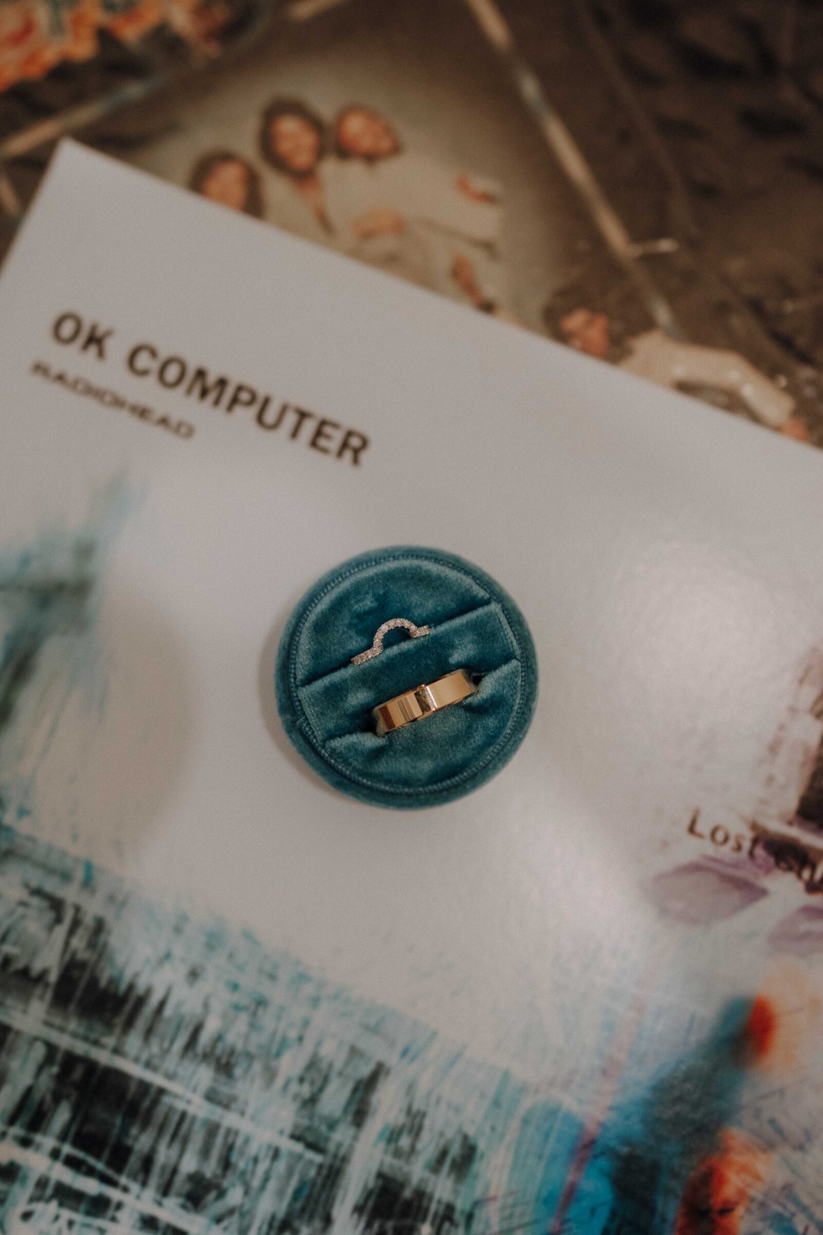 A gold ring in a blue velvet box is placed on a Radiohead "OK Computer" album.